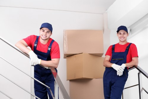 Professional movers loading desks into a moving truck.